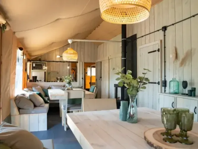 Vista interior de la tienda safari Medley Lodge con jacuzzi, decoración de madera clara y ambiente acogedor.