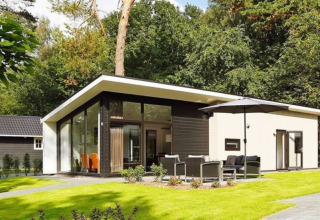Modern holiday homes at Bospark Markelo, surrounded by lush greenery and trees in Overijssel, Netherlands.