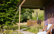 Safari-telt med privat varmt brusebad og træbadekar ved Feather Down Pant y March Farm i Storbritannien.