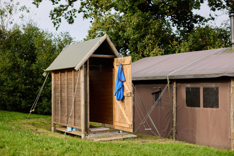 Safari tent with private hot shower beside the tent and hot tub at Feather Down Billingsmoor Farm, UK.