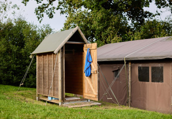 Safari tent with private hot shower beside the tent and hot tub at Feather Down Billingsmoor Farm, UK.