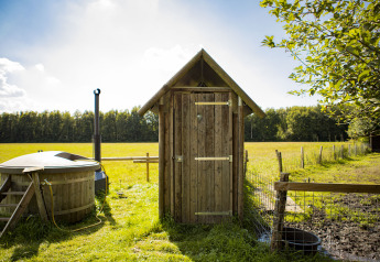 Vue d’une cabane en bois et bain à remous privé à Feather Down De Lange Weide aux Pays-Bas.