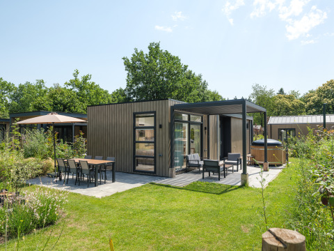 Casa moderna en Batenburgh Deluxe con terraza, muebles de jardín y espacio verde rodeado de vegetación.
