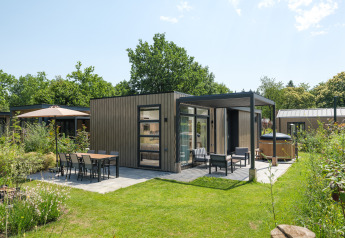 Casa moderna en Batenburgh Deluxe con terraza, muebles de jardín y espacio verde rodeado de vegetación.