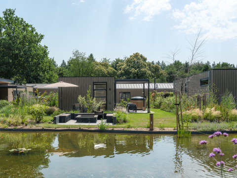 Moderno lodge presso uno stagno a Batenburgh Deluxe, Veluwepark de Bosgraaf, con giardino e area relax.