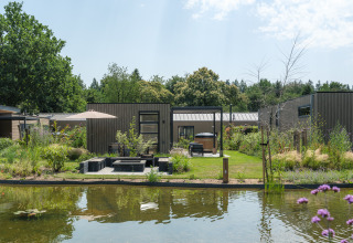 Moderno lodge presso uno stagno a Batenburgh Deluxe, Veluwepark de Bosgraaf, con giardino e area relax.