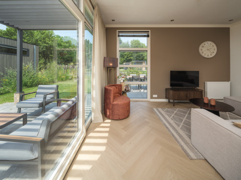 Soggiorno moderno con grandi finestre al Batenburgh Deluxe, Veluwepark de Bosgraaf, Paesi Bassi, vista giardino