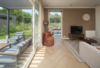 Soggiorno moderno con grandi finestre al Batenburgh Deluxe, Veluwepark de Bosgraaf, Paesi Bassi, vista giardino