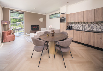 Modernes Wohnzimmer und Küche in der Batenburgh Deluxe Lodge im Veluwepark de Bosgraaf, Niederlande, stilvoll eingerichtet.