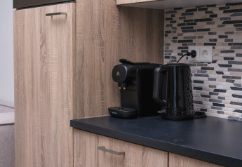 Moderne Küchenarbeitsplatte mit Kaffeemaschine und Wasserkocher im Batenburgh Deluxe, Veluwepark de Bosgraaf, Niederlande.