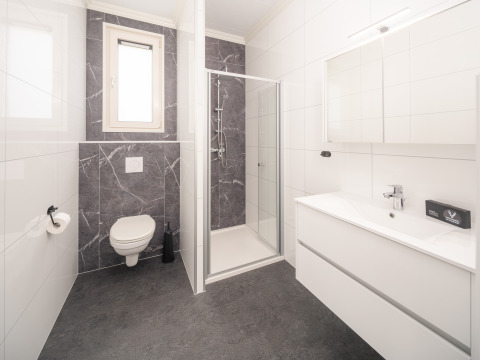 Bagno moderno al Batenburgh Deluxe, Veluwepark de Bosgraaf, Paesi Bassi, con doccia, WC e lavabo.
