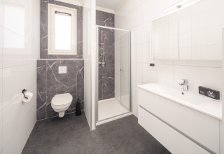 Bagno moderno al Batenburgh Deluxe, Veluwepark de Bosgraaf, Paesi Bassi, con doccia, WC e lavabo.
