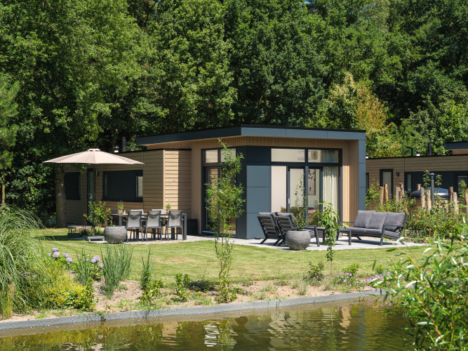 Moderne Lodge am See im Veluwepark de Bosgraaf in den Niederlanden mit Terrasse und Garten.
