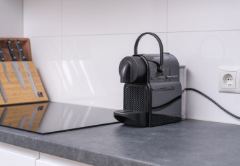 Coin cuisine moderne au glamping avec machine à café Nespresso et bloc couteaux sur un plan lisse.