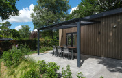 Modern covered patio with dining table at Loevestein Deluxe lodge in Veluwepark de Bosgraaf, Netherlands.