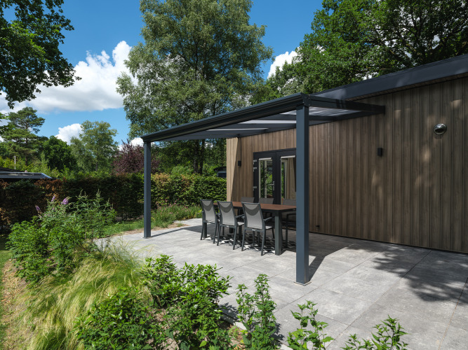 Moderne überdachte Terrasse mit Essbereich am Loevestein Deluxe im Veluwepark de Bosgraaf in den Niederlanden.