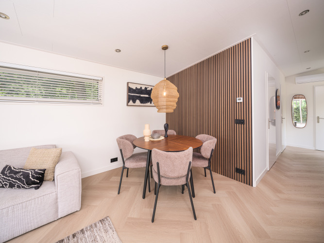 Modernes Wohnzimmer in der Loevestein Deluxe Lodge im Veluwepark de Bosgraaf mit stilvollem Essbereich.