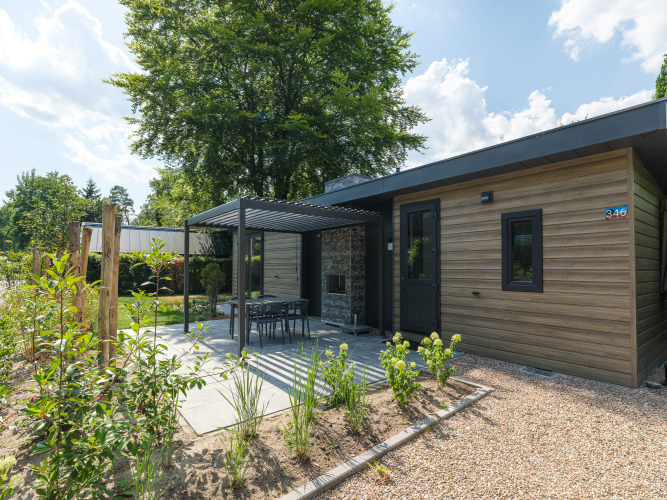 Cabaña moderna de madera y piedra con terraza y jardín en Veluwepark de Bosgraaf, Zypendaal, Países Bajos.