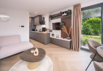 Lodge moderne Zypendaal à Veluwepark de Bosgraaf, Pays-Bas, avec salon lumineux, cuisine et vue sur jardin.