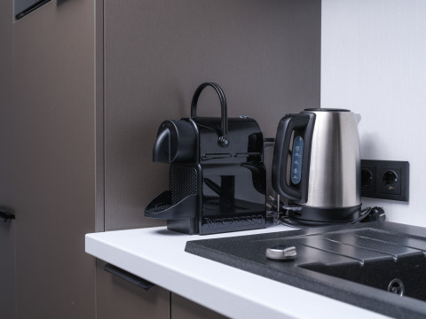 Modern Nespresso coffee machine and electric kettle on a white countertop in Zypendaal lodge, Veluwepark de Bosgraaf.