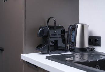 Macchina da caffè Nespresso moderna e bollitore su piano cucina bianco nel lodge Zypendaal, Veluwepark de Bosgraaf.