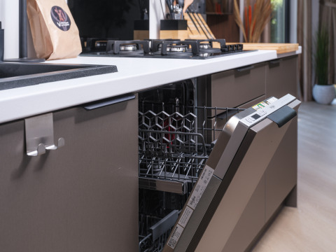 Modern kitchen at Zypendaal lodge in Veluwepark de Bosgraaf, Netherlands, featuring an open dishwasher.