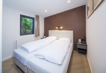 Camera da letto al lodge Zypendaal presso Veluwepark de Bosgraaf, Paesi Bassi, con letto matrimoniale e arredo moderno.