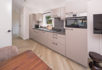 Cucina moderna di una lodge con mobili chiari, elettrodomestici a incasso e tavolo in legno.