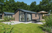 Moderne Doornenburg Lodge au Veluwepark de Bosgraaf, Pays-Bas, entourée de verdure et de nature luxuriante.