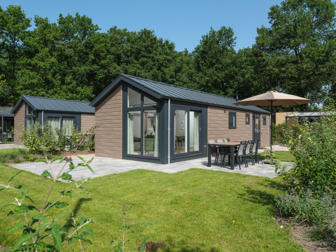 Moderne Doornenburg Lodge im Veluwepark de Bosgraaf, Niederlande, umgeben von viel Grün und Natur.