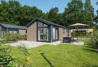 Buitenaanzicht van Doornenburg Lodge op Veluwepark de Bosgraaf in Nederland met terras en tuin.