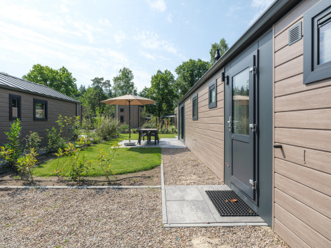 Buitenruimte bij Doornenburg Lodge in Veluwepark de Bosgraaf, Nederland, met terras en groenvoorziening.