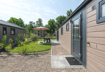 Area esterna della Doornenburg Lodge presso il Veluwepark de Bosgraaf nei Paesi Bassi con patio e giardino.