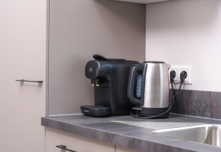 Coin cuisine moderne avec une cafetière Philips et une bouilloire au Doornenburg Lodge Comfort à Veluwepark.