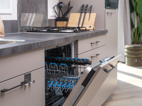Moderne keuken met open vaatwasser, gaskookplaat en messenblok in Doornenburg Lodge Comfort, Veluwepark de Bosgraaf.