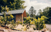 Modernes Tiny House im Veluwepark de Bosgraaf in den Niederlanden mit Garten und viel Natur.