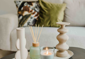 Table basse décorée dans une tiny house avec bougie allumée, diffuseur de parfum et vases décoratifs.