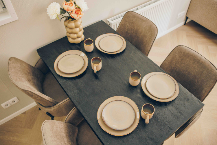 Mesa de comedor con cuatro servicios y un jarrón de flores en un Tiny Loft en Veluwepark de Bosgraaf, Países Bajos.