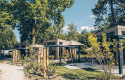 Außenansicht der Reeëndal Lodge im Veluwepark de Bosgraaf in den Niederlanden, umgeben von Natur.
