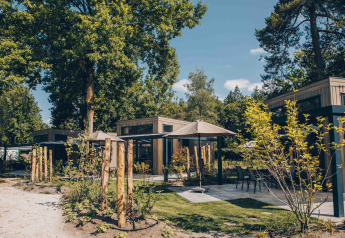 Außenansicht der Reeëndal Lodge im Veluwepark de Bosgraaf in den Niederlanden, umgeben von Natur.
