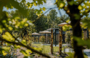 Espace verdoyant avec lodges modernes, parasols et arbres à Reeëndal Lodge Comfort avec Hottub aux Pays-Bas.
