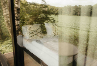 Udsigt gennem vinduet på Nokken NKN-18 Cabin ved Wilsumer Berge, Tyskland, med natur udenfor.