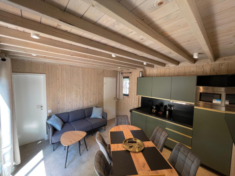 Stijlvol interieur van de Eco Lodge bij Hameau de l'Ourthe in België, met houten wanden en modern design.