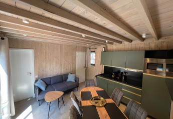 Stilfuldt interiørbillede af Eco Lodge på Hameau de l'Ourthe i Belgien med trævægge og moderne møbler.
