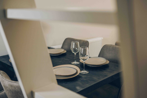 Moderne eettafel met borden en wijnglazen in Tiny Loft van Veluwepark de Bosgraaf, Nederland.