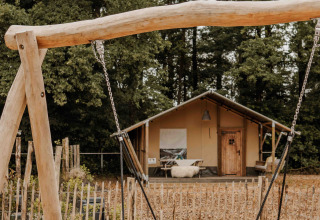 Tienda safari con columpio redondo al frente en Veluwepark de Bosgraaf, Países Bajos.