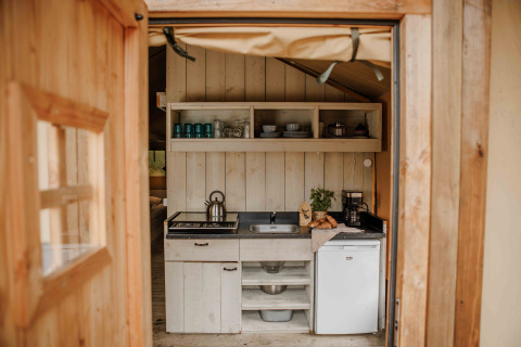 Vista de una cocina acogedora dentro de una tienda safari en Veluwepark de Bosgraaf, Países Bajos.