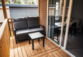 Træterrasse med grå bænk og bord ved Loggia Wood på Eurocamping Vessem BV i Holland