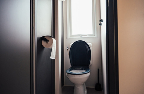 Badezimmer mit Toilette, schwarzem Sitz, Toilettenpapier und Fenster, Loggia Wood, Eurocamping Vessem BV, Niederlande.