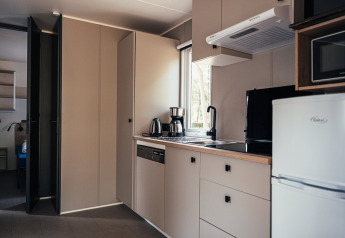 Moderne tekøkken i Loggia Wood-lodge på Eurocamping Vessem BV, Holland, med apparater og opbevaring.